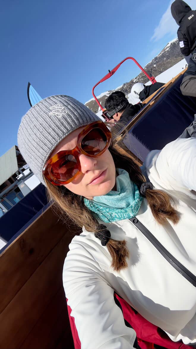 Person wearing sunglasses and a beanie in a mountainous area