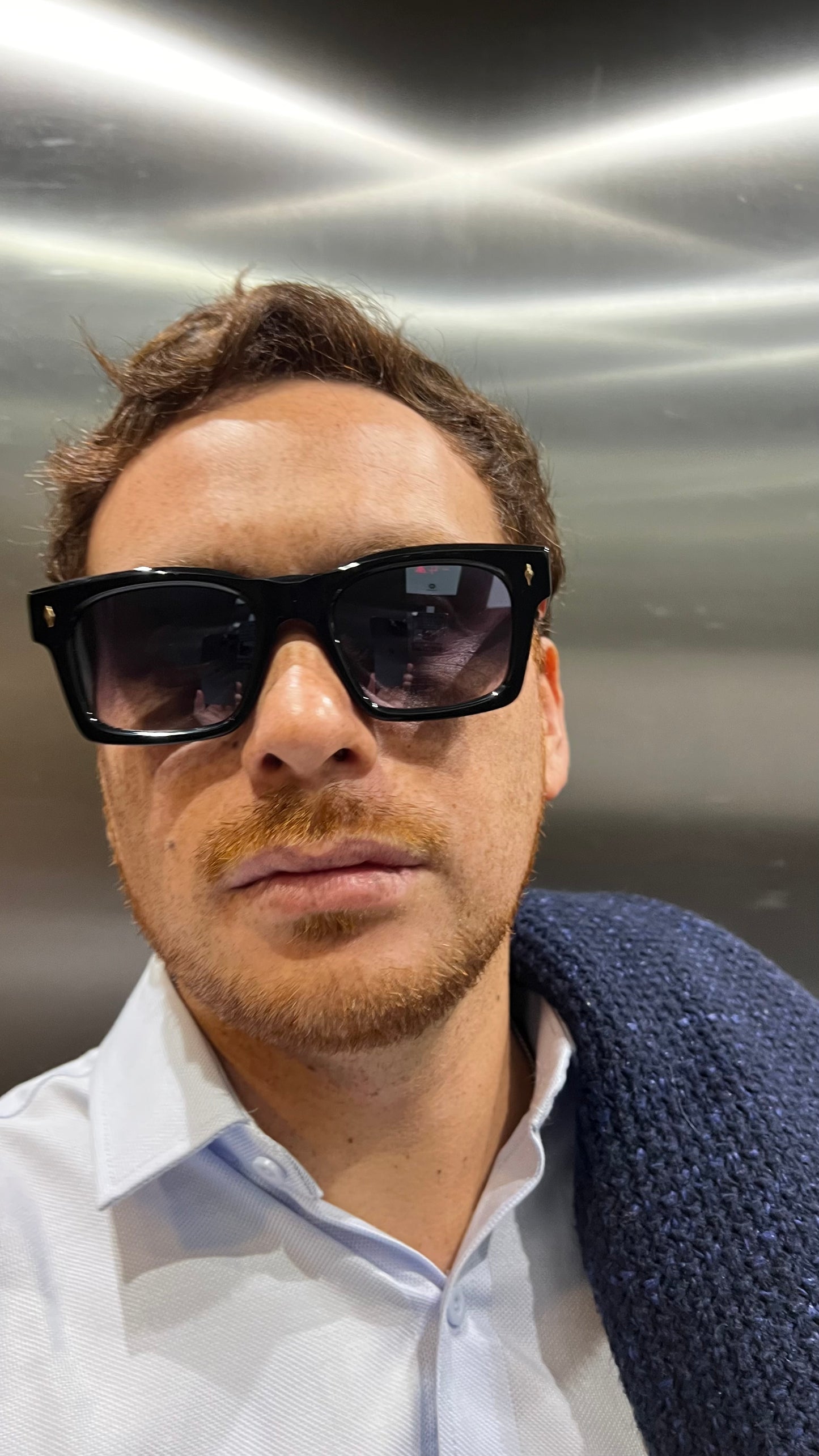 Man wearing sunglasses in an elevator setting