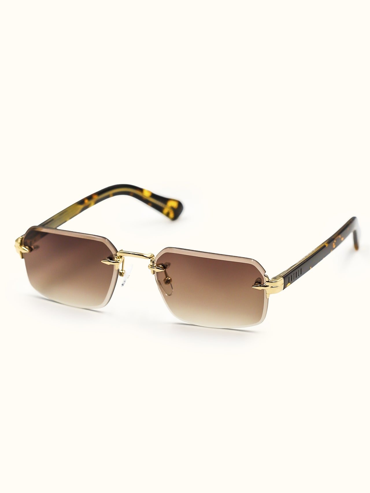 Sunglasses with gold frame and tortoiseshell arms on a white background