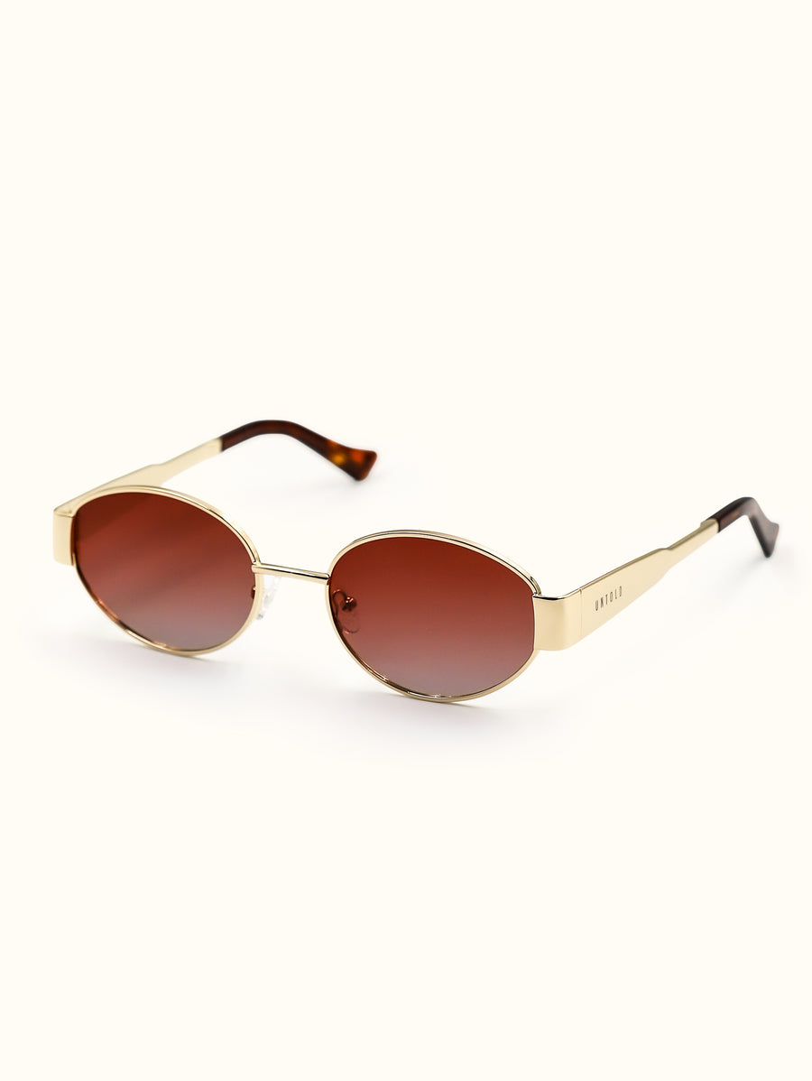 Gold-framed sunglasses with brown lenses on a white background