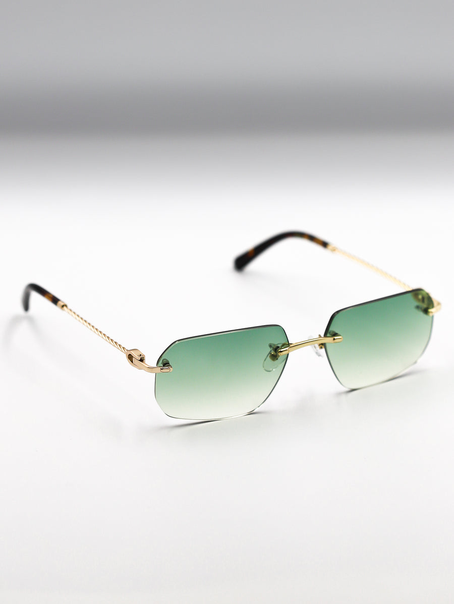 Sunglasses with gold frame and green gradient lenses on a light gray background