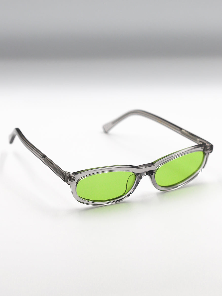 Sunglasses with green lenses and clear frames on a gradient background