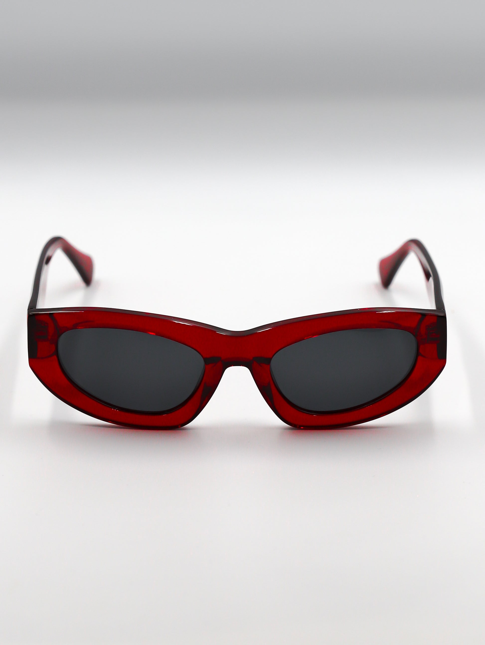 Red sunglasses with dark lenses on a white background