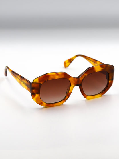 Tortoiseshell sunglasses with brown lenses on a light gray background