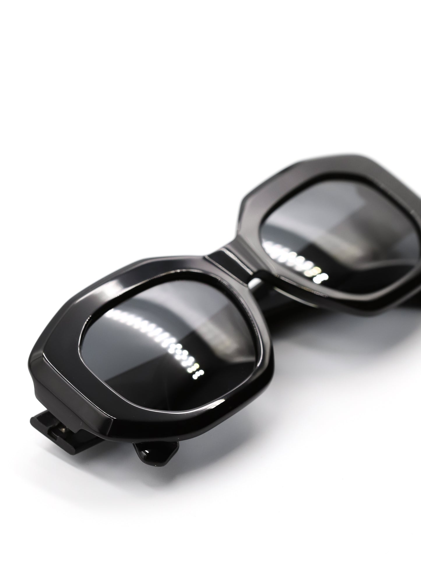 Black sunglasses with reflective lenses on a white background