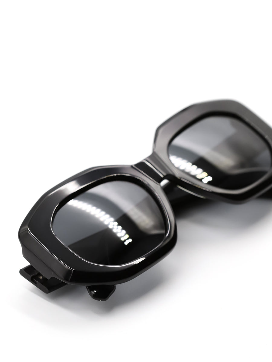 Black sunglasses with reflective lenses on a white background