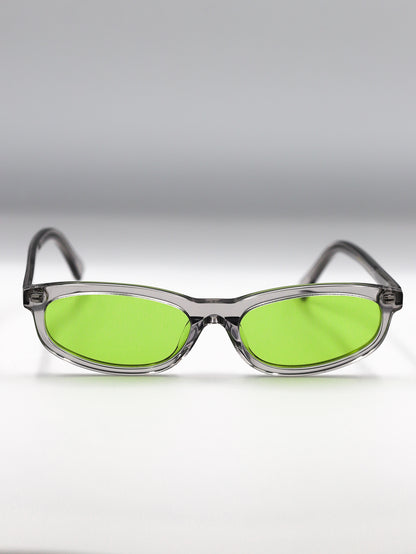 Sunglasses with green lenses and clear frames on a gradient gray background