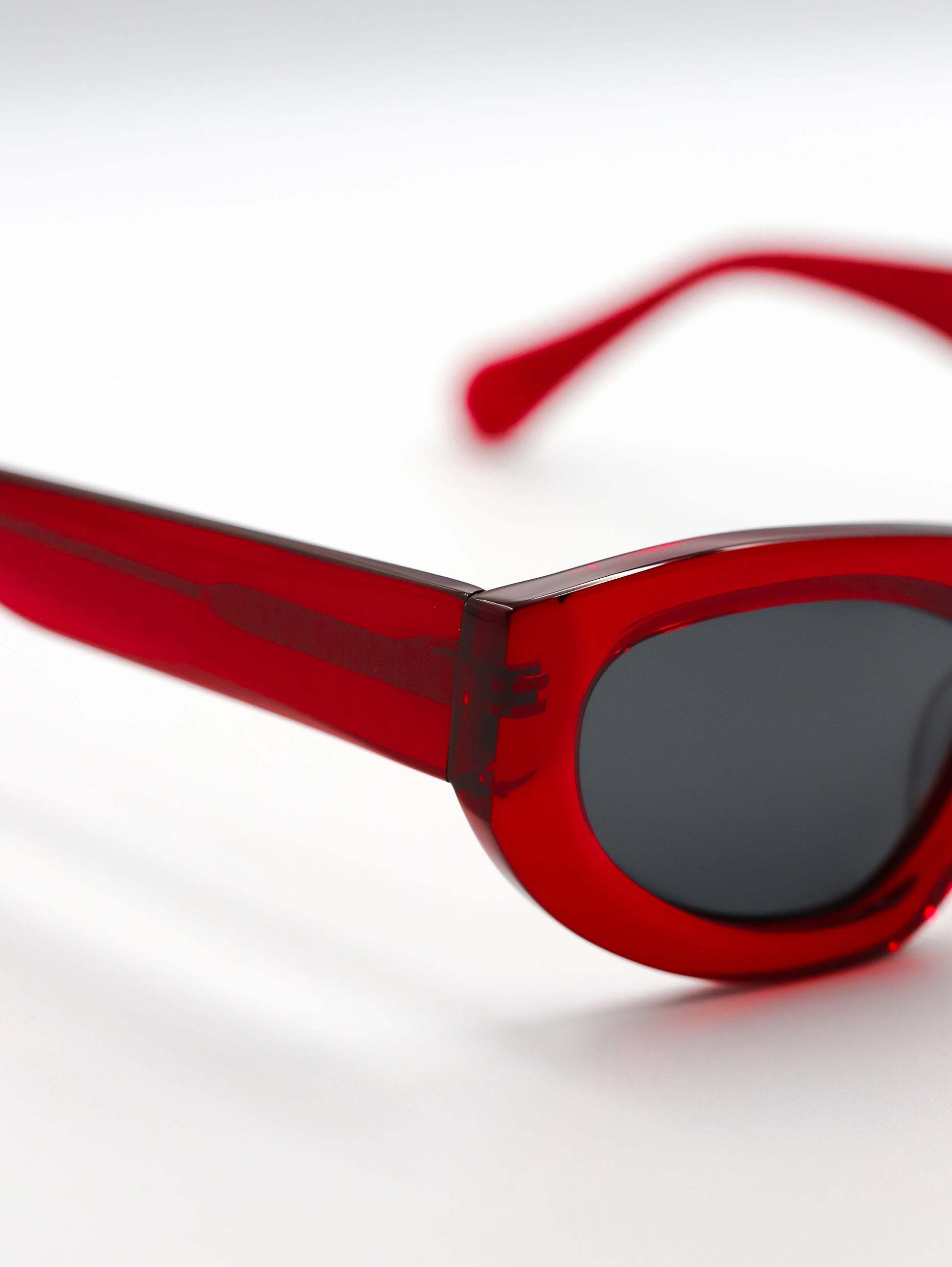 Red sunglasses with a clear lens on a white background