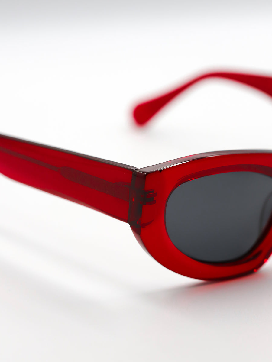 Red sunglasses with a clear lens on a white background