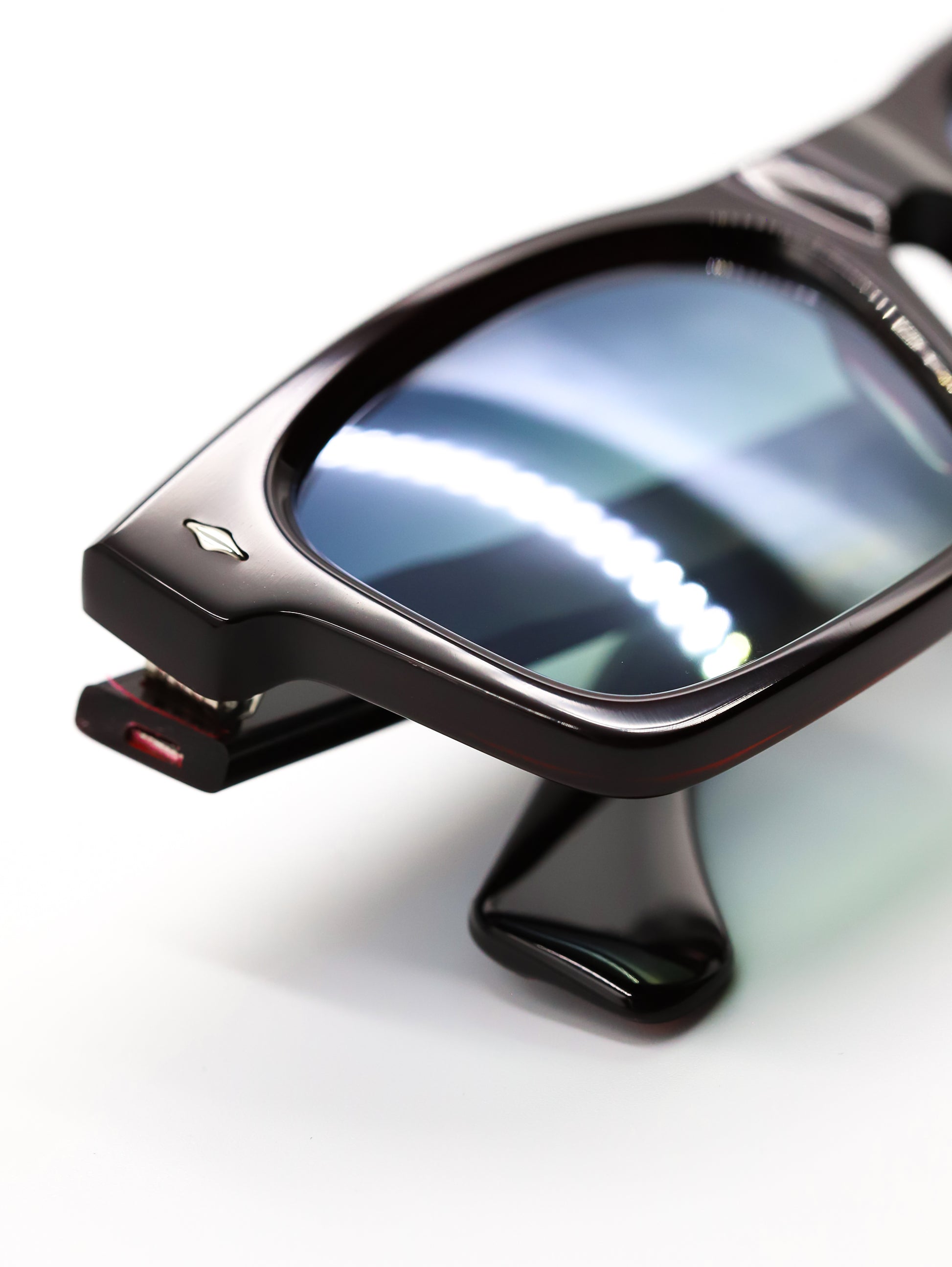 Close-up of a pair of sunglasses with reflective lenses on a white background