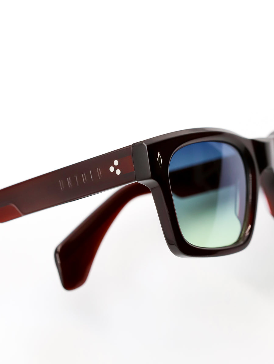 Sunglasses with a brown frame and blue-tinted lenses on a white background