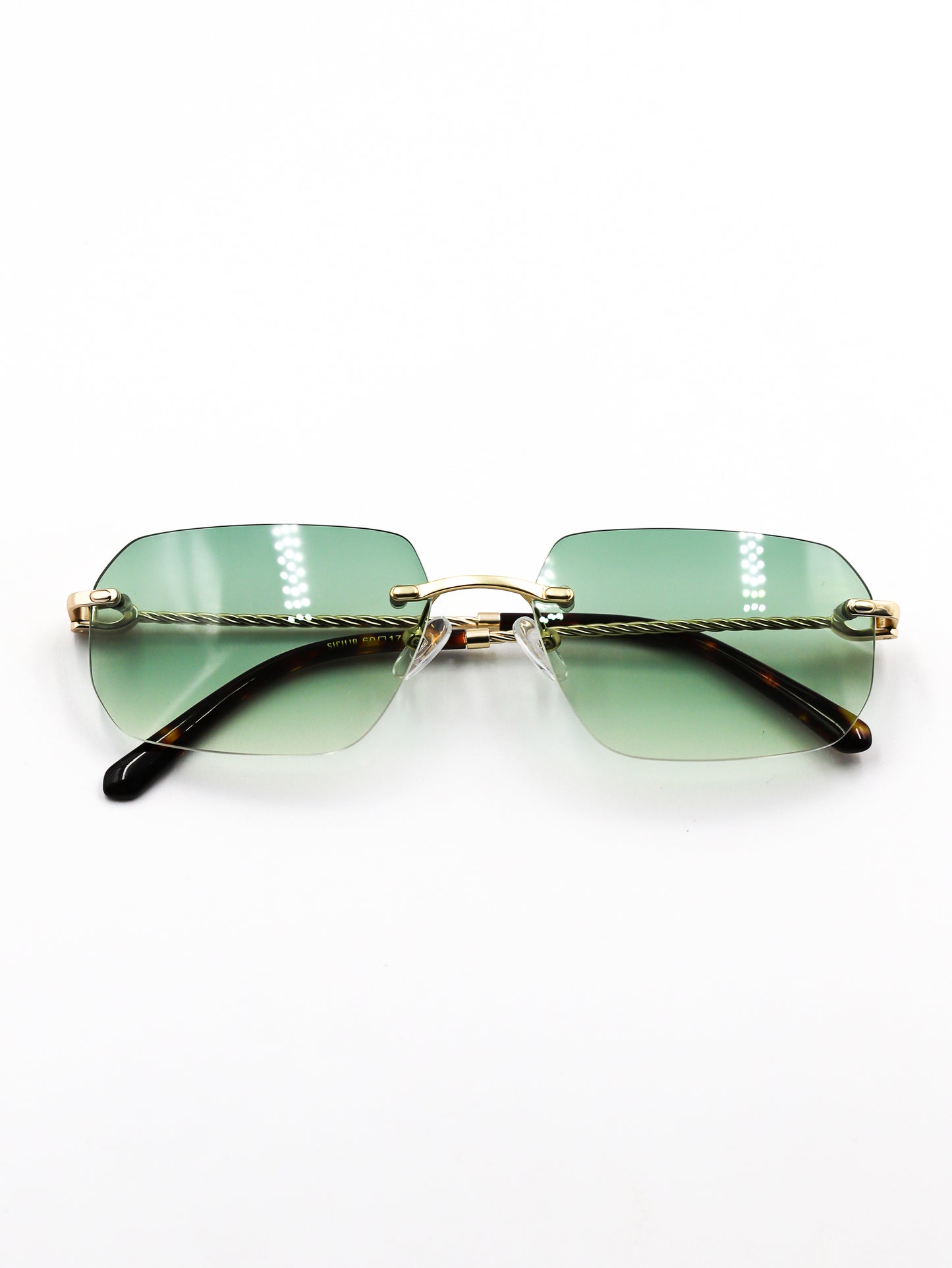 Sunglasses with green gradient lenses and gold frame on a white background