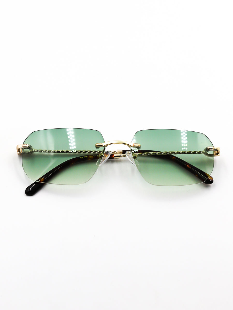 Sunglasses with green gradient lenses and gold frame on a white background