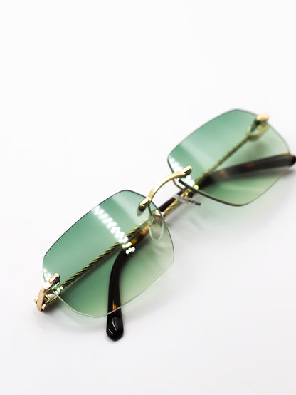 Green sunglasses with gold frames on a white background