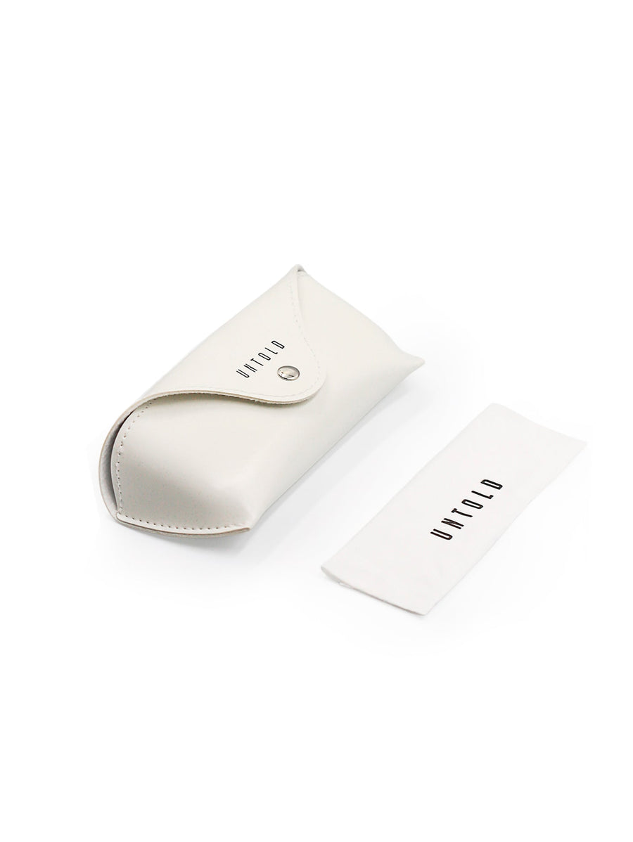 UNTOLD branding on a card and packaging on a reflective surface with blurred background